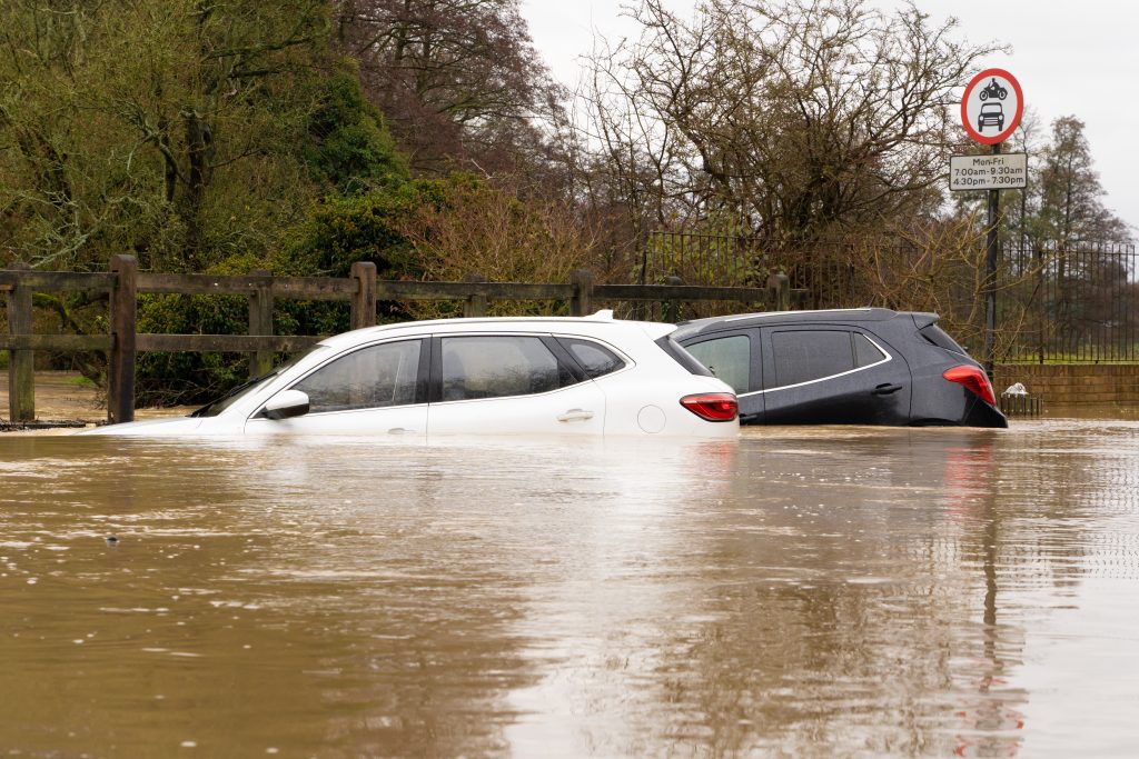 Broken down cars submerged in a flooded ford after heavy rain